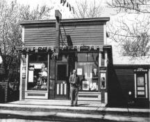 Camille Bordage photographié devant sa pharmacie vers les années 1930. L’enseigne se lit : « Kent Drug Store ». Une petite extension à la droite abrite un comptoir de crème glacée.; Private collection