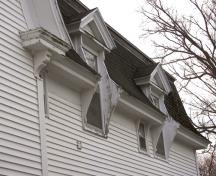 Les lucarnes à fronton avec leurs lambrequins verticaux en bois qui servent de larges consoles; Bernard LeBlanc