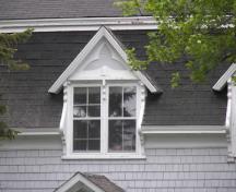 La lucarne centrale de la façade principale avec ses lambrequins verticaux en bois qui servent de larges consoles; Bernard LeBlanc