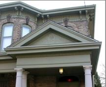 Featured is the gable supported by four wooden posts, decorated with a floral design.; City of Brantford, 2009.