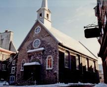 Side view of the Notre-Dame-des-Victoires Church National Historic Site of Canada, showing the main façade, 1988.; Agence Parcs Canada / Parks Canada Agency, Architectural History Branch, 1988.