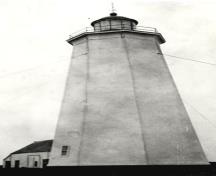 General view of Miscou Island Lighthouse National Historic Site of Canada, showing its octagonal massing and tapered profile, 1933.; Agence Parcs Canada / Parks Canada Agency, Ministry of Transport, 1933