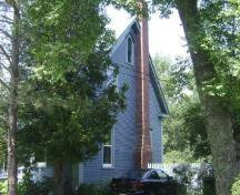 This photograph shows the side façade of the residence with the Gothic attic window, wide eave returns and cornerboards, 2009; Town of St. Andrews