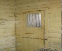 Interior cell door with barred window and hand-wrought hasp, 2004.; Government of Saskatchewan, Marvin Thomas, 2004.