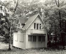 Vue de l'extérieur du garage et domicile des domestiques, qui montre le petit balcon à l’étage, au-dessus des portes du garage, 1984.; Parks Canada Agency / Agence Parcs Canada, M. Trépanier, 1984.