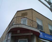 Cette image montre le petit balcon surplombant l’entrée en angle.; Village of Saint Quentin