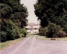 View of the main entrance to Inverarden House, showing its pyramidal roofed entrance porch with a classically inspired central entrance, flanked by casement windows, 1994.; Parks Canada Agency / Agence Parcs Canada, 1994.