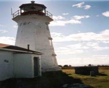 General view of the Lighthouse, showing the attractive tower and plinth-like base, the tapered shaft with a well defined octagonal shape and a flared cornice, 2004.; Department of Transport / Ministère des Transports et Communications, 2004.
