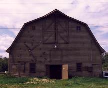 View of the front of the Barn, showing its functional character reflected in the profile and texture of the wood siding, 1995.; Parks Canada Agency / Agence Parcs Canada, 1995.