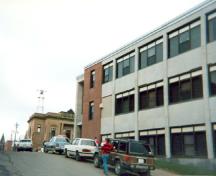 Façade latérale du l'édifice du gouvernement du Canada, qui montre les murs en brique avec accents en grès et les bandes de fenêtres, 1995.; Agence Parcs Canada / Parks Canada Agency, 1999.