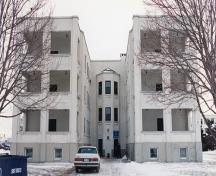 Vue de l'extérieur du bâtiment 21, qui montre le toit plat, les lignes pures et les revêtements de finition en stuc peint en blanc, 1994.; Department of National Defence / Ministère de la Défense nationale, 1994.