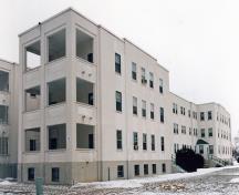 View of the exterior of Building 23, showing the classical, symmetrical planning and Moderne and Art Deco styling as expressed by its clean lines and painted-white stucco finishes, 1994.; Department of National Defence / Ministère de la Défense nationale, 1994.