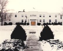 View of the façade of the Officers' Mess, showing the projecting entry with a small amount of traditional ornamentation, such as the lettering above the doors, 1994.; Department of National Defence / Ministère de la Défense nationale, 1994.