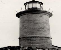 General view of the Lighthouse, showing the massing, which consists of a circular tower, and concrete lantern platform which is surmounted by a cupola.; National Archives of Canada / Archives nationales du Canada.