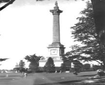 View of Brock's Monument, showing the monument’s tall, elegant form and geometric massing which consists of a tall circular column on a square base, ca. 1920.; Archives of Ontario / Archives publiques de l'Ontario, ca./vers 1920.