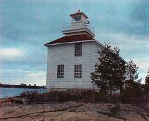 Façade of the Lighttower, showing the short and squared light tower, rising directly above the center of the dwelling.; Canadian Coast Guard / Garde côtière canadienne.