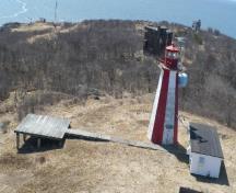 General view of the Partridge Island Light Tower, showing its colour pattern, with each side painted alternately in red or white.; Canadian Coast Guard / Garde côtière canadienne.