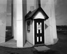 Vue de l'avant du phare, qui montre le portique d’entrée, qui évoque une construction résidentielle, 1990.; Parks Canada Agency / Agence Parcs Canada, 1990.