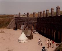 View of the Casemates, showing its façade constructed of stone with projecting chimneys, 1991.; Agence Parcs Canada / Parks Canada Agency, 1991.