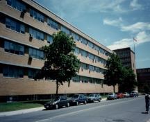 Façade latérale de l’édifice des minéraux chimiques radioactifs, qui montre les longues bandes de fenêtres à cadre en aluminium dotées d’appuis en pierre proéminents et de brise-soleil en saillie.; Agence Parcs Canada / Parks Canada Agency.