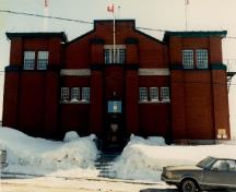View of the Armoury, showing the elements of the fortress motif expressed in square corner towers flanking the front façade, 1989.; Ministère de la Défense nationale / Department of National Defence, 1989.