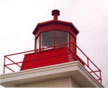 Vue en détail du phare côtier, qui montre la corniche rectangulaire et sa lanterne métallique et vitrée, 2000.; Department of Fisheries and Oceans / Ministère des Pêches et des Océans, 2000.