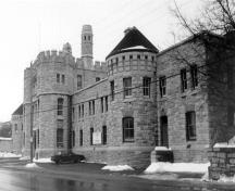 Façade of the Armoury, showing the prominent three-storey projecting frontispiece, consisting of a troop door and two flanking stair towers, 1989.; Parks Canada Agency / Agence Parcs Canada, J. Adell, 1989.
