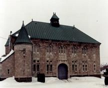 Side view of the Armoury, showing the symmetrical projecting corner pavilions each with turrets and corner tower pinnacles, 1990.; Department of National Defence / Ministère de la Défense nationale, 1990.