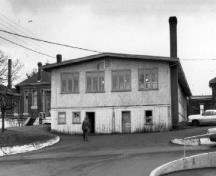 Vue arrière du bâtiment 37, qui montre les fondations surélevées.; Parks Canada Agency / Agence Parcs Canada, 1970.