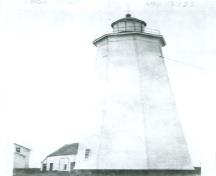Historical view of the Tower at Miscou Island, showing the building’s form and massing, consisting of a tapered octagonal tower, tall profile, surmounted by a lantern, 1933.; Environment Canada, Architectural History Branch / Environnement Canada, Direction de l'histoire de l'architecture, 1933.
