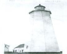 Vue historique du Phare de l'île Miscou, qui montre la forme et le volume du bâtiment, soit une tour effilée et octogonale, un haut profil et un fût surmonté d’une lanterne, 1933.; Environment Canada, Architectural History Branch / Environnement Canada, Direction de l'histoire de l'architecture, 1933.