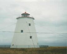 Façade latérale du Phare à l'île Miscou, qui montre les fenêtres à linteaux en forme de fronton qui percent le fût, 1990.; Department of Transport / Ministère des Transports, 1990.