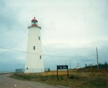 West elevation of the Tower at Miscou Island, showing the exterior finished in white with red trim, 1990.; Department of Transport / Ministère des Transports, 1990.