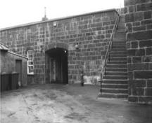 Vue de l'entrée principale du bâtiment 21, qui montre la solide construction de maçonnerie du rez-de-chaussée, 1991.; Parks Canada Agency / Agence Parcs Canada, Rhona Goodspeed, 1991.