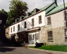 Vue de l'entrée principale du bâtiment 2, qui montre la construction de maçonnerie massive du rez-de-chaussée et le parement en stuc de l’étage, 1993.; Parks Canada Agency / Agence Parcs Canada, Jocelyne Cossette, 1993.