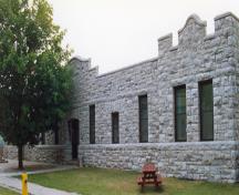 General view of RMC Building 24, showing the long, symmetrical, single-volume mass and the elaborated roof lines.; Parks Canada Agency / Agence Parcs Canada.