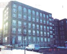 Rear view of the Gulf Fisheries Centre, showing the abundant and regular fenestration with its strong vertical emphasis and grid like pattern, 1993.; Department of Fisheries and Oceans / Ministère des Pêches et des Océans, 1993.