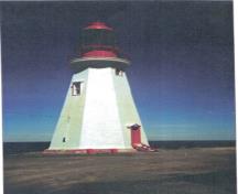 Vue arrière du Phare, qui montre la combinaison du rouge et du blanc qui fait ressortir la séparation entre la base, le fût et la lanterne, 1990.; Canadian Coast Guard / Garde côtière canadienne, 1990.