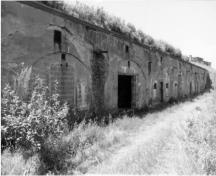 Vue de l'extérieur des casemates, qui montre la construction de plusieurs baies qui forment les casemates contiguës et la disposition des ouvertures de chaque baie, 1996.; Parks Canada Agency / Agence Parcs Canada, 1996.