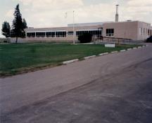 Vue générale de l'école Ralston (R2), qui montre l'horizontalité marquée par la forme et la volumetrie du bâtiment et les fenêtres formant des bandes horizontales, 1996.; Department of National Defence / Ministère de la Défense nationale, 1996.