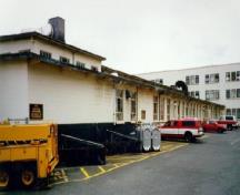 Façade latérale du bâtiment 34, qui montre la façade à l’horizontalité prononcée et le toit plat, 1993.; Department of National Defence / Ministère de la Défense nationale, 1993.