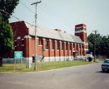 Side elevation of the Barrie Armoury, showing the primary building materials including concrete, red brick, and limestone trim, 1997.; Department of National Defence / Ministère de la Défense nationale, 1997.