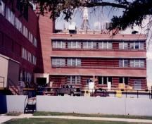 Vue de l'arrière du Laboratoire central (B-1), où l'on peut apercevoir l’horizontalité prononcée de la forme et de la volumétrie, les bandeaux de fenêtres et les brise-soleil, 1997.; Parks Canada Agency / Agence Parcs Canada, 1997.