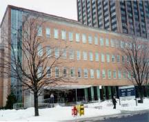 Façade du bâtiment de l'administration, qui montre les grands pans de parement en brique et les longues rangées horizontales de fenêtres, 1998.; Parks Canada Agency / Agence Parcs Canada, J. Mattie, 1998.