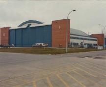 Vue en angle du Hangar d'aviation no 6, qui montre les façades sud-est et nord-est, où l'on peut apercevoir le toit légèrement courbé et les larges portes, 2000.; Department of National Defence / Ministère de la Défense nationale, 2000.