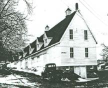 Vue générale du bâtiment 16, qui montre la petite échelle du bâtiment, le toit à deux versants bas revêtu de bardeaux, les petites fenêtres et le revêtement de planches à clins, 1948.; Department of Agriculture / Ministère de l'Agriculture, 1948.