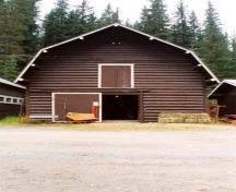 Facade of the Horse Barn at Yoho Ranch depicting the south elevation and demonstrating the simple, symmetrical and well-proportioned composition of this rectangular barn which features a large entrance door, second level hayloft doors, and a gambrel roof,; Cultural Resource Services, Calgary, 1999