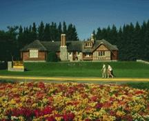 Panoramic view of the Park Administration Building showing the retention of the original relationship of the building to the roadway and to the landscaped gardens, mature trees and lawns of Central Park, 1986.; Parks Canada Agency / Agence Parcs Canada, Barrett & MacKay, 1986