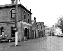 Vue générale du bâtiment D51 démontrant sa forme, son échelle et son rapport avec les bâtiments connexes voisins datant de la même époque, 1989.; Parks Canada Agency / Agence Parcs Canada, I. Doull, 1989.