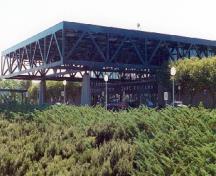 General view of the VIA Rail Station showing the massive, concrete, pier-and-girder structure which supports the space-frame roof, and extends to form canopies at the front and back of the building.; Parks Canada Agency / Agence Parcs Canada, n.d.